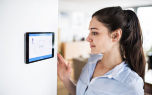 Woman Adjusting Smart Thermostat