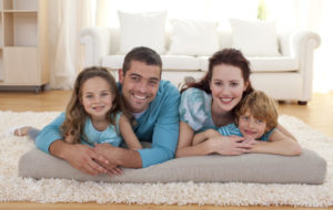 Happy Family On Rug In Living Room