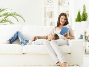 Mother Reading To Child On Couch